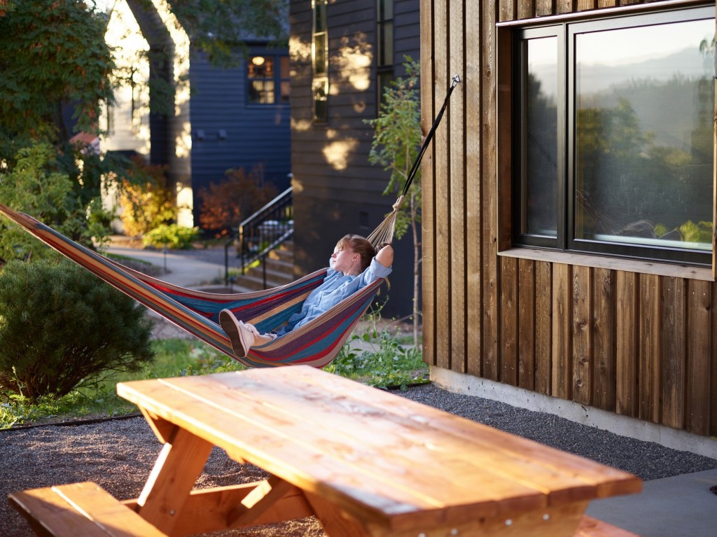 woman in backyard hammock relaxing